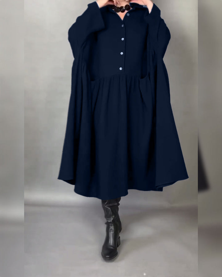 Navy blue button-front A-line dress with point collar and long sleeves, gathered skirt.