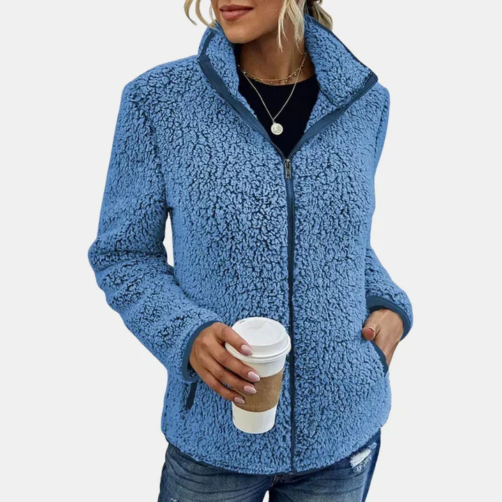 Blue teddy jacket with full-zip front and side pockets, worn with jeans.