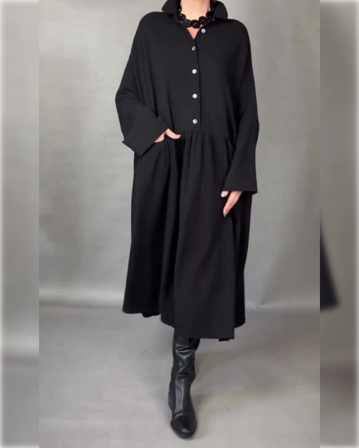 Black A-line button-front dress with point collar, long sleeves, and flared skirt.
