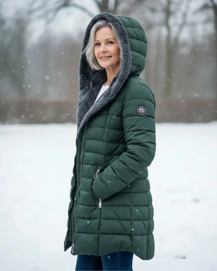 Dark green padded winter jacket with gray hood lining, side view, front zipper.