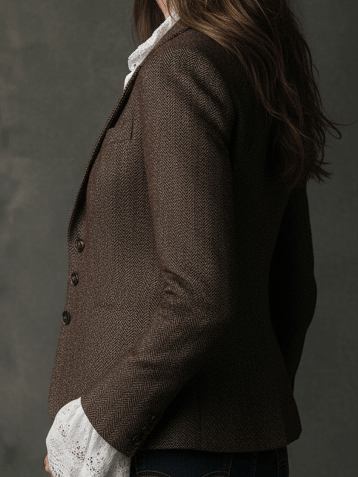 Women's brown tweed blazer side profile with buttoned sleeve cuff and structured shoulders.