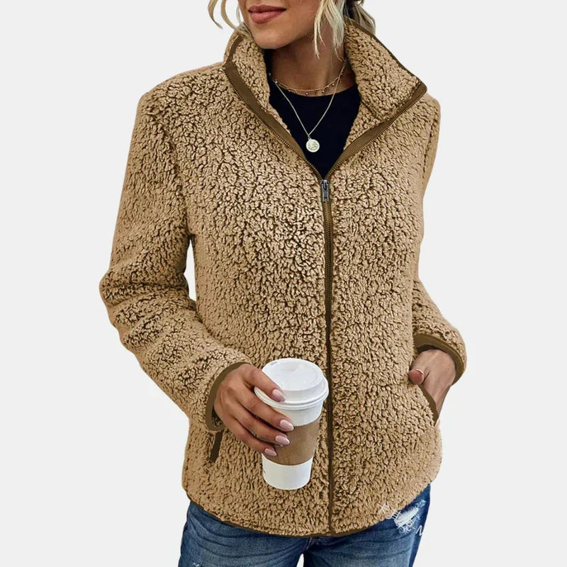 Beige teddy jacket with full-zip front and side pockets, worn with jeans.
