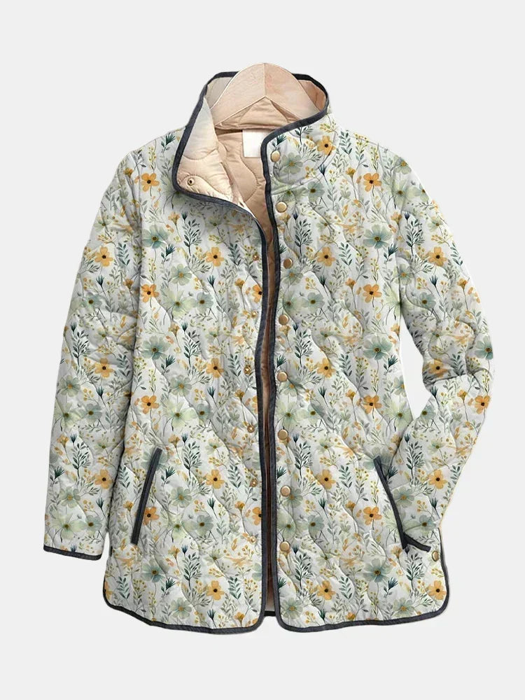 Floral quilted hooded jacket, light base with yellow and green flowers, navy zipper.