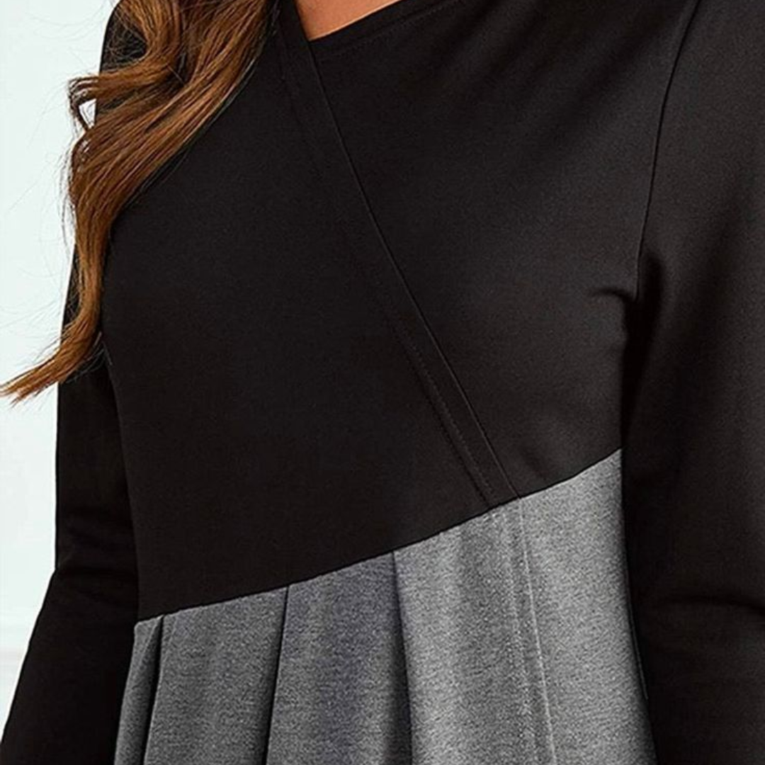 Close-up: black bodice with diagonal seam over gray gathered fabric midi dress