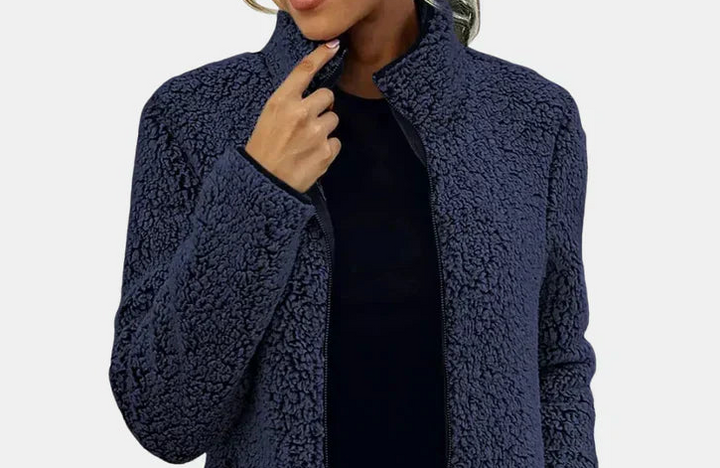 Dark blue teddy jacket close-up with stand collar and zip front