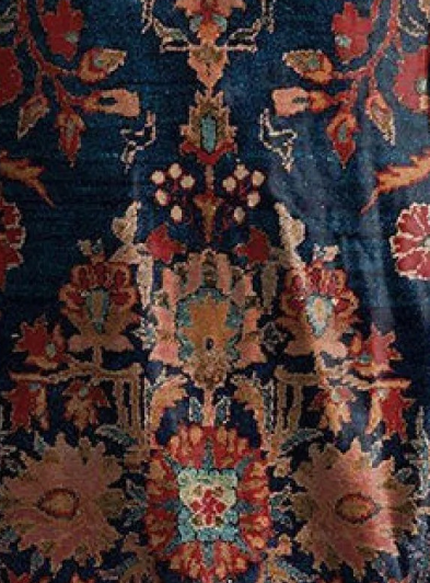 Floral print fabric close-up on navy base with red, orange, and cream motifs