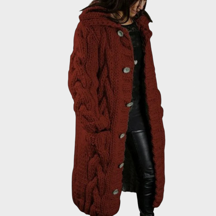 Rust red cable-knit hooded cardigan with button front and textured cable knit pattern.