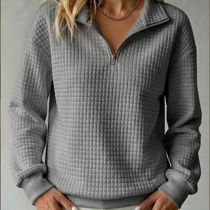 Gray quilted quarter-zip sweater with stand collar, zip front, and ribbed hem