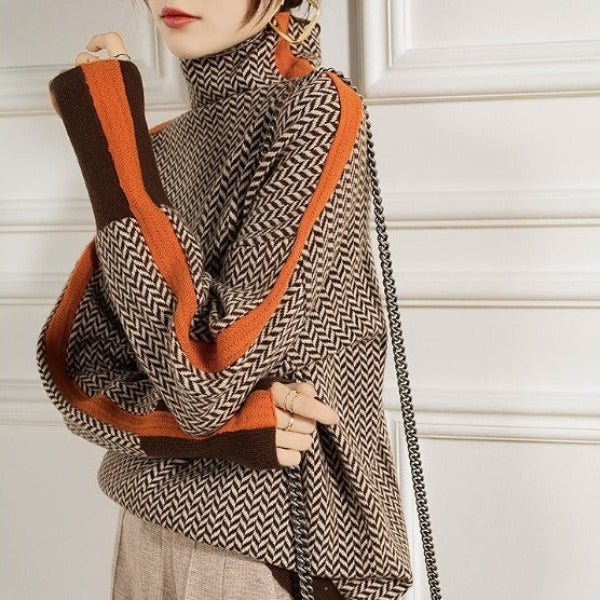 Women’s roll neck chevron jumper with orange contrast trim along shoulder and sleeve