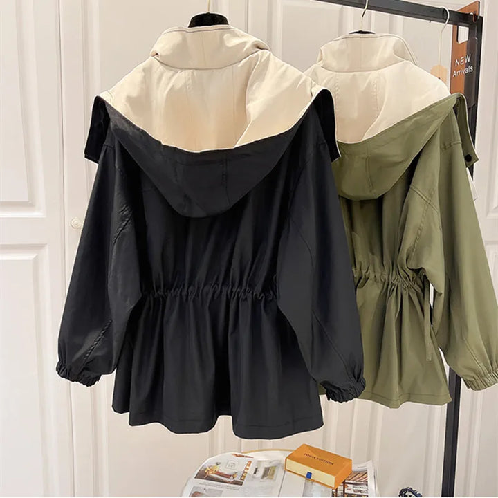Windbreaker jackets with hoods on hangers, black and green colors