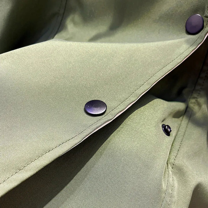 Olive green windbreaker fabric with purple button snaps and stitched seam.