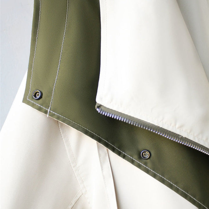 Olive and white windbreaker hem with snap buttons and stitched trim.
