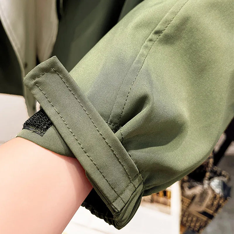 Green windbreaker jacket sleeve with elastic cuff and stitched seam detail