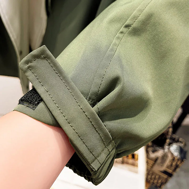 Green windbreaker jacket sleeve with elastic cuff and stitched seam detail