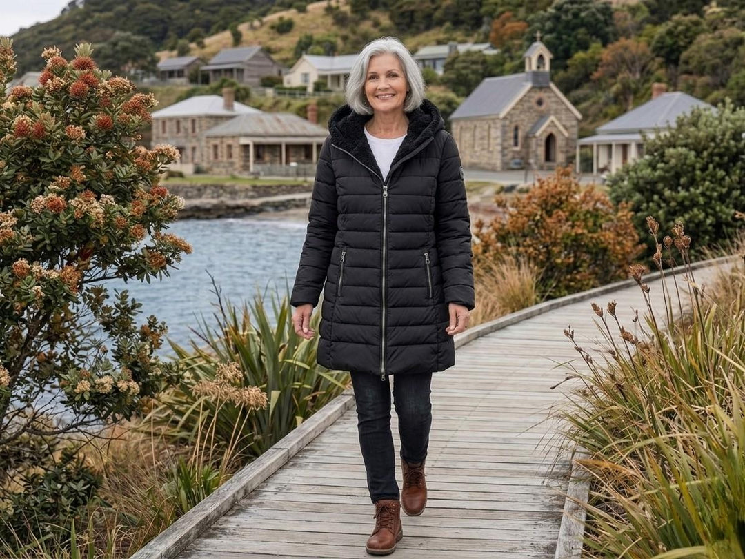 Black quilted A-line winter coat with hood and zip front, side zip pockets.