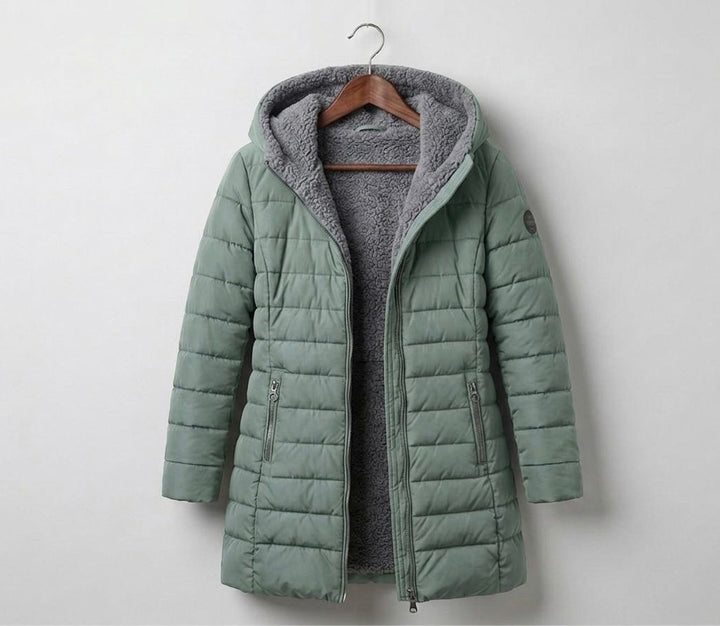 Light green quilted A-line winter coat with hood, front zip, and side zip pockets.
