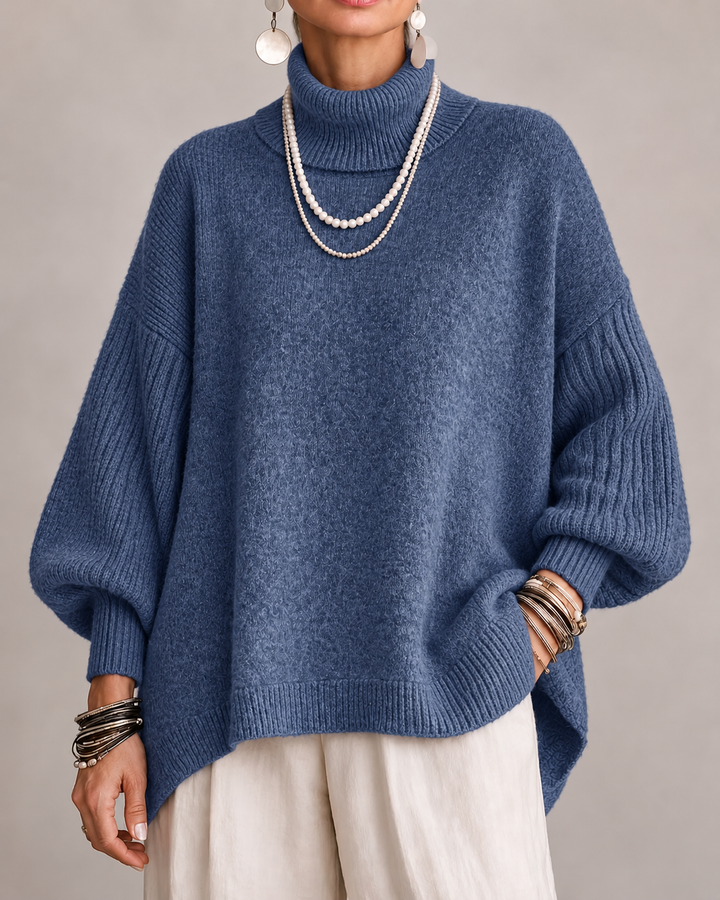 Blue turtleneck knit sweater with ribbed cuffs and relaxed dolman sleeves.