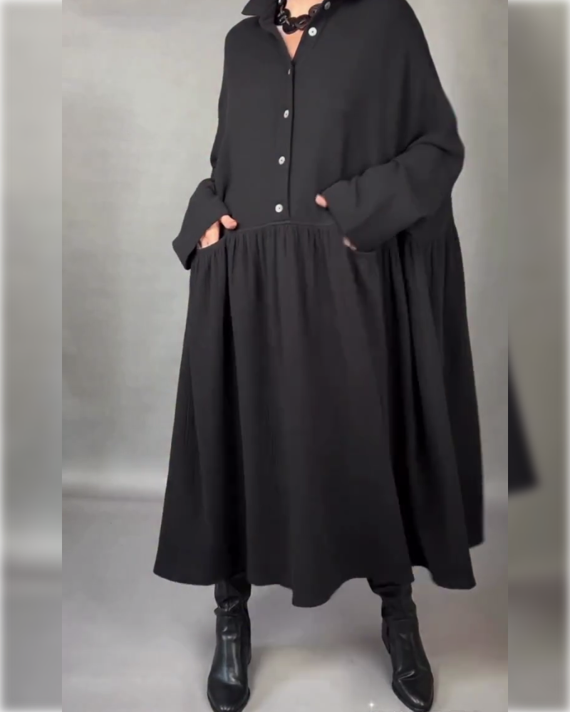 Black A-line button dress with point collar, long sleeves, and gathered skirt.