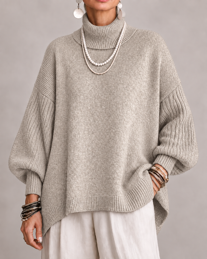 Beige turtleneck knit sweater with ribbed cuffs and relaxed dolman sleeves.