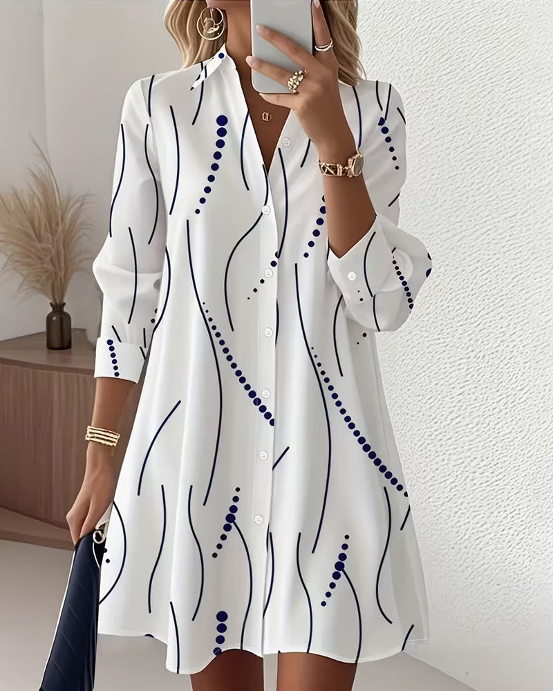 White wavy-pattern shirt dress with navy buttons and long sleeves, curved collar