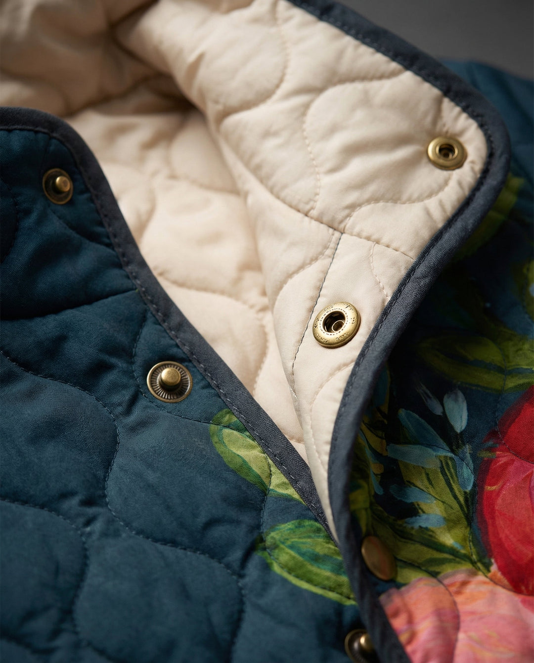 Close-up of quilted jacket collar and gold snap buttons with tan lining