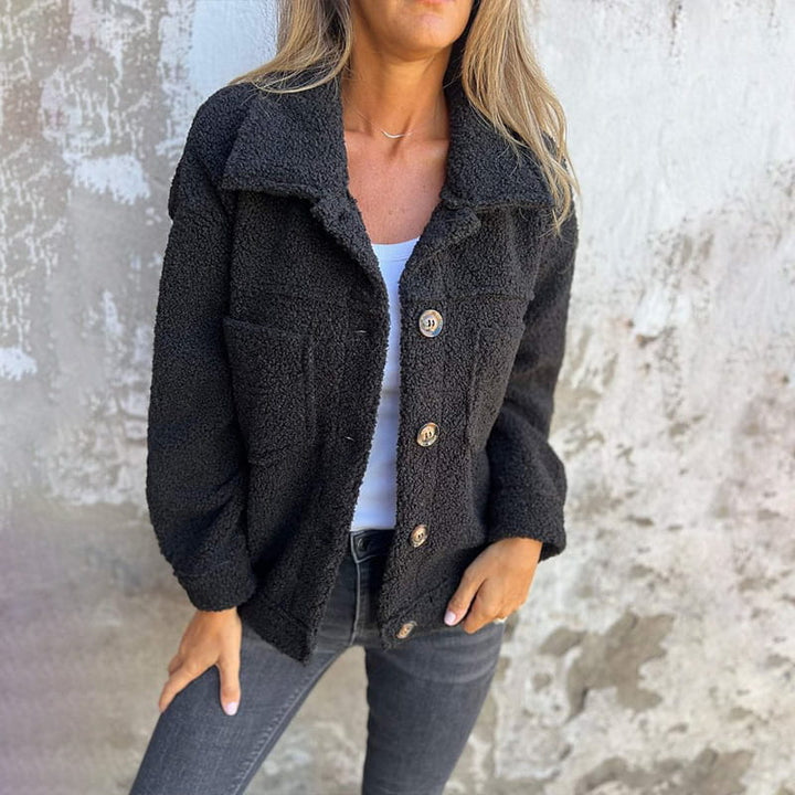 Black teddy jacket with button closure, point collar, and two flap chest pockets