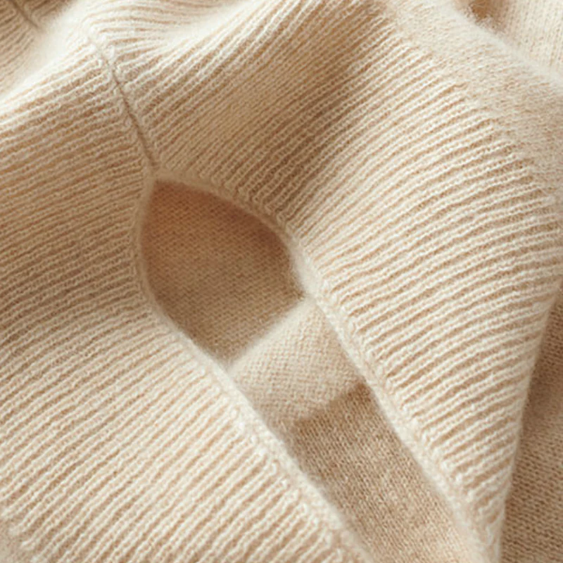 Close-up of cream-beige merino wool knit with fine ribs and seams