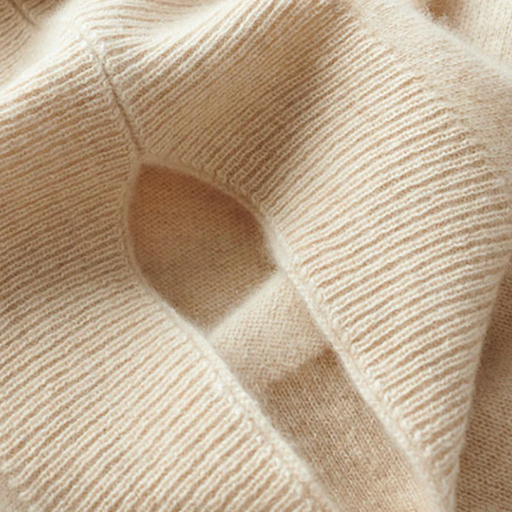 Close-up of cream-beige merino wool knit with fine ribs and seams