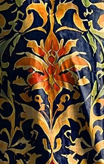 Close-up of dark blue tunic dress print with gold and orange-red floral ornament