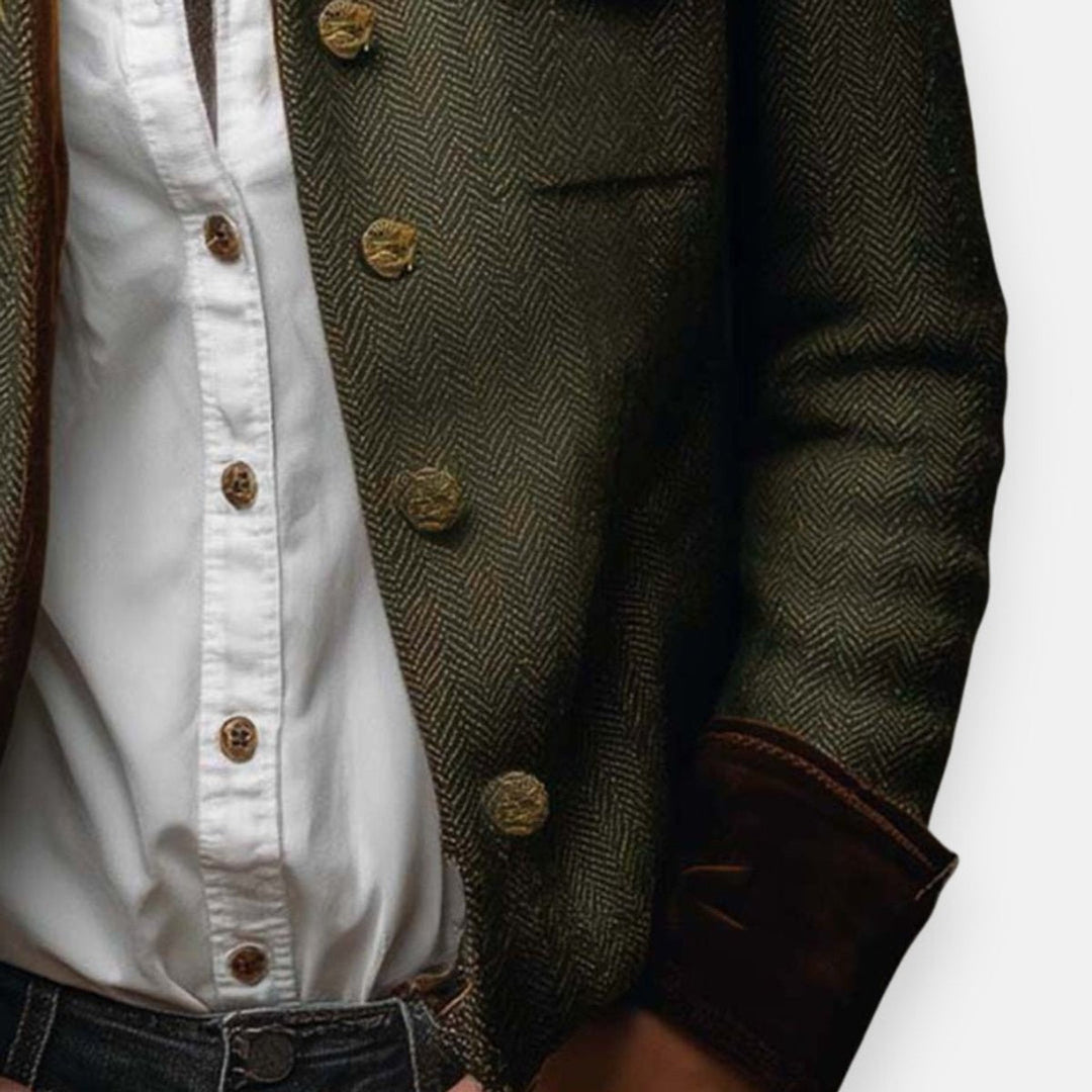 Close-up of olive herringbone military jacket with brass buttons and flap pocket