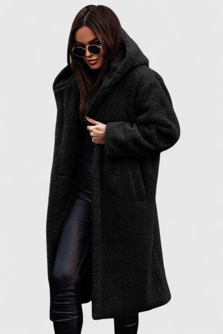 Black long hooded winter coat with fuzzy texture, buttoned front and front pockets.