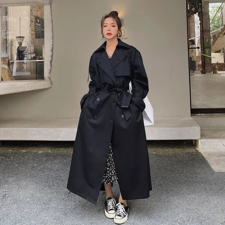 Navy long trench coat with double-breasted button front, belt tie, and collar