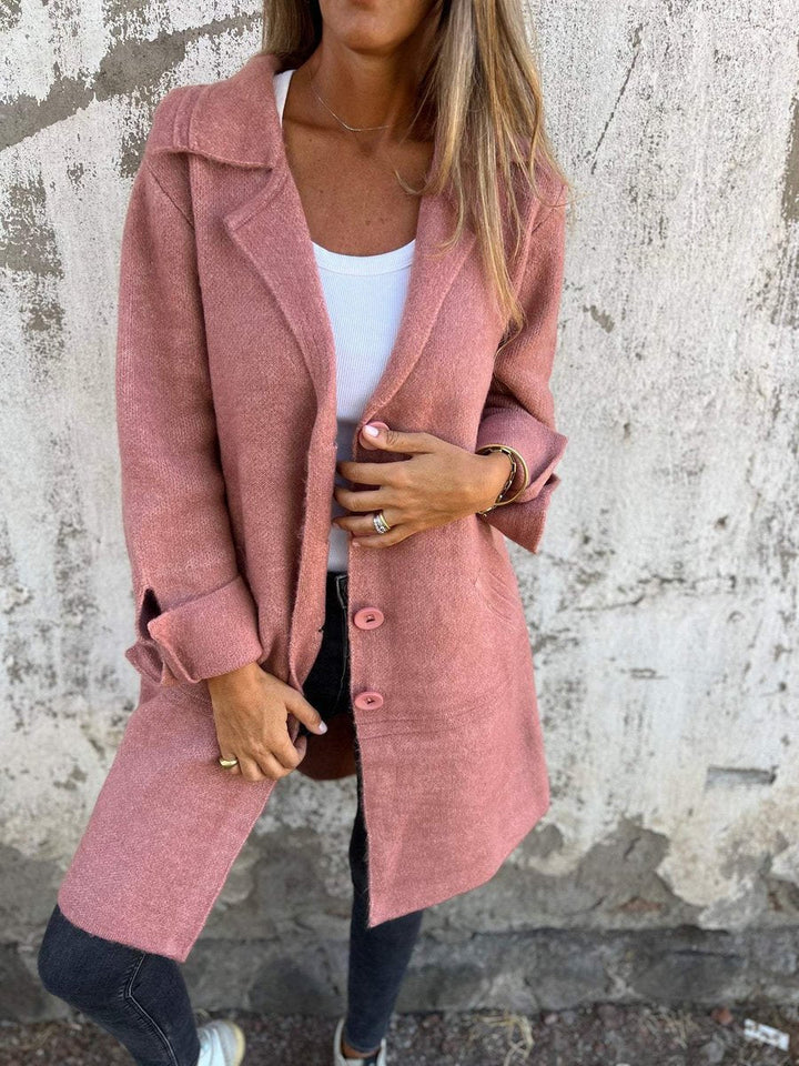 Pink long coat with lapel collar and button front, long sleeves, side pockets.